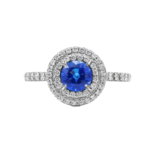 A 0.75-carat round-cut Sapphire set in a double halo of 0.50-carat pavé diamonds. Crafted in 18K white gold with additional pavé diamonds on the band, bringing the total carat weight to 1.25.